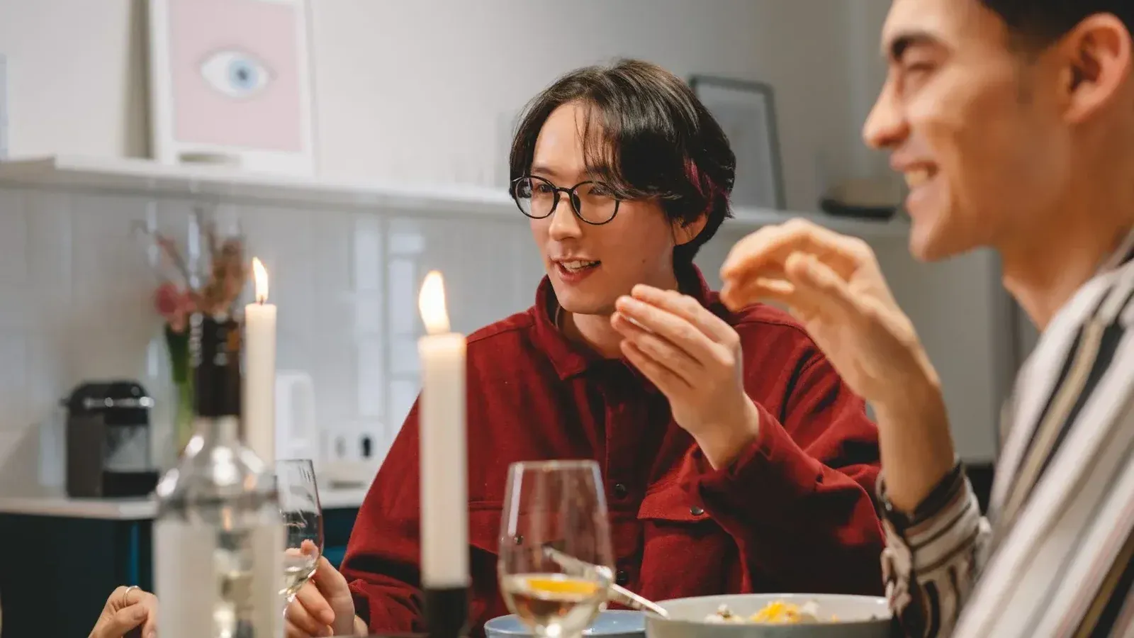 Una cena amistosa con amigos diversos disfrutando de la comida y la conversación en el interior.