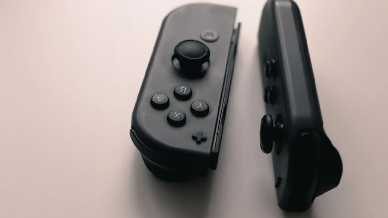 Una imagen de cerca de dos controladores Joy-Con de Nintendo Switch sobre un fondo neutro.