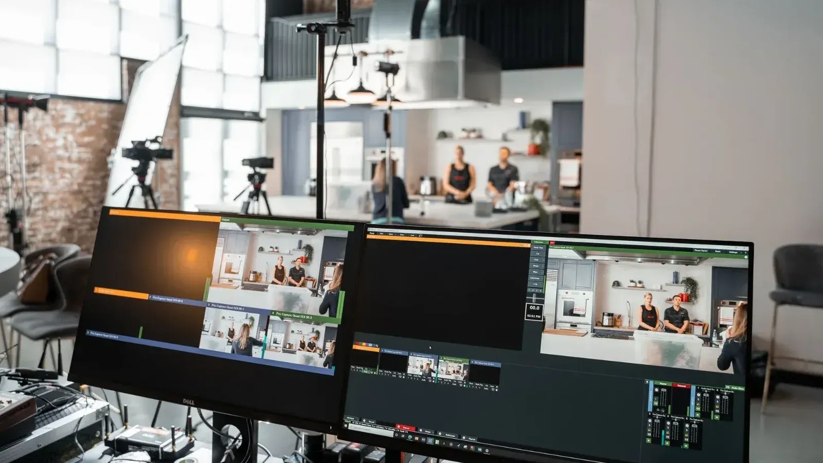 Una configuración dinámica en un estudio de producción de video con dos monitores y un entorno de cocina.