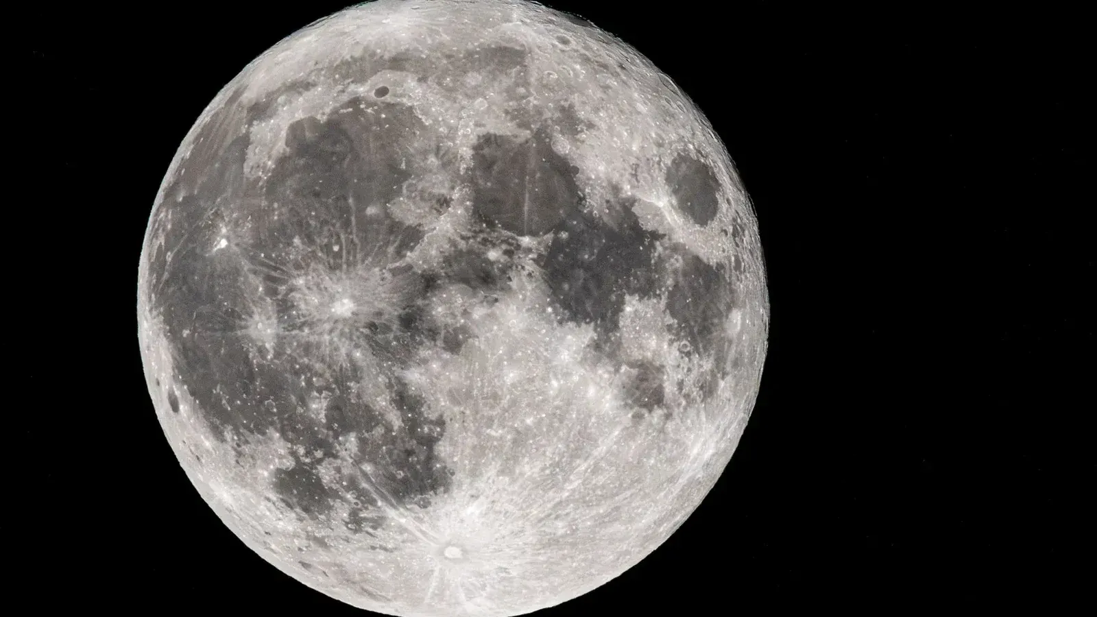 Imagen de primer plano de la luna llena que captura características de superficie detalladas contra un cielo nocturno negro.