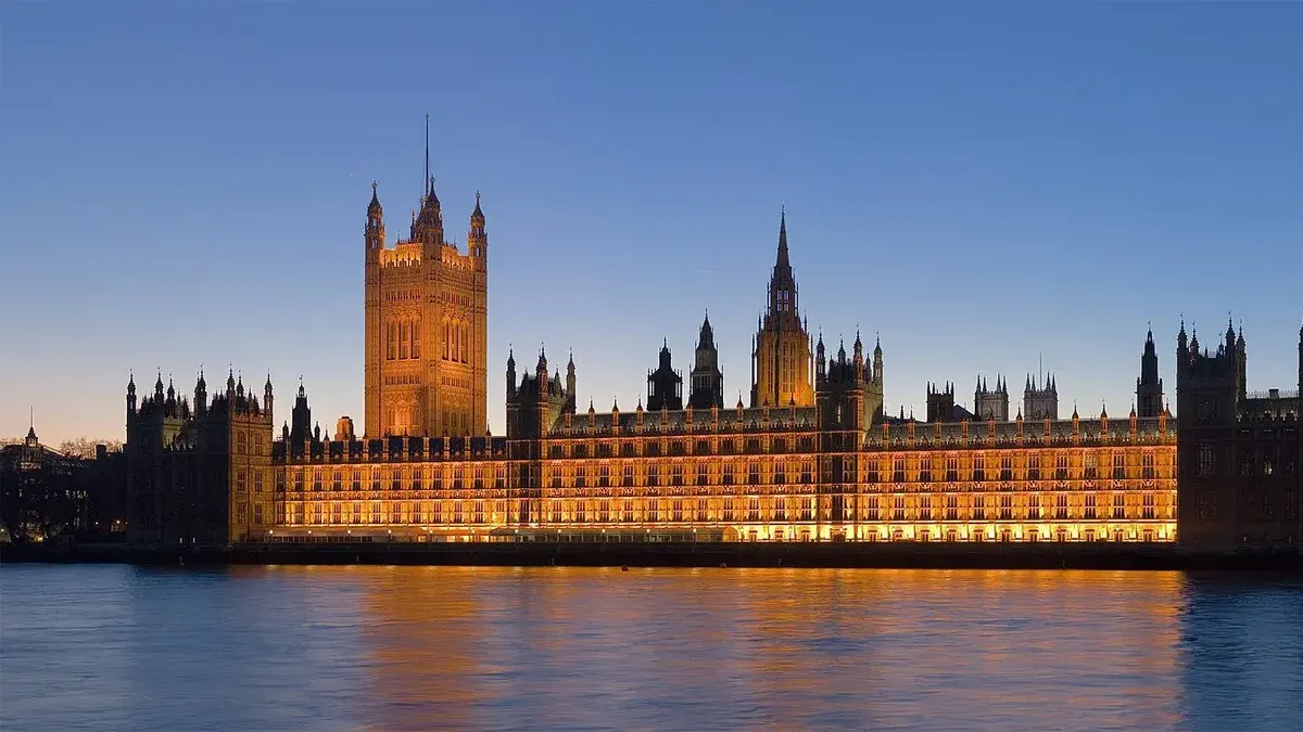 The Palace of Westminster at night as seen from the opposite side of the River Thames.