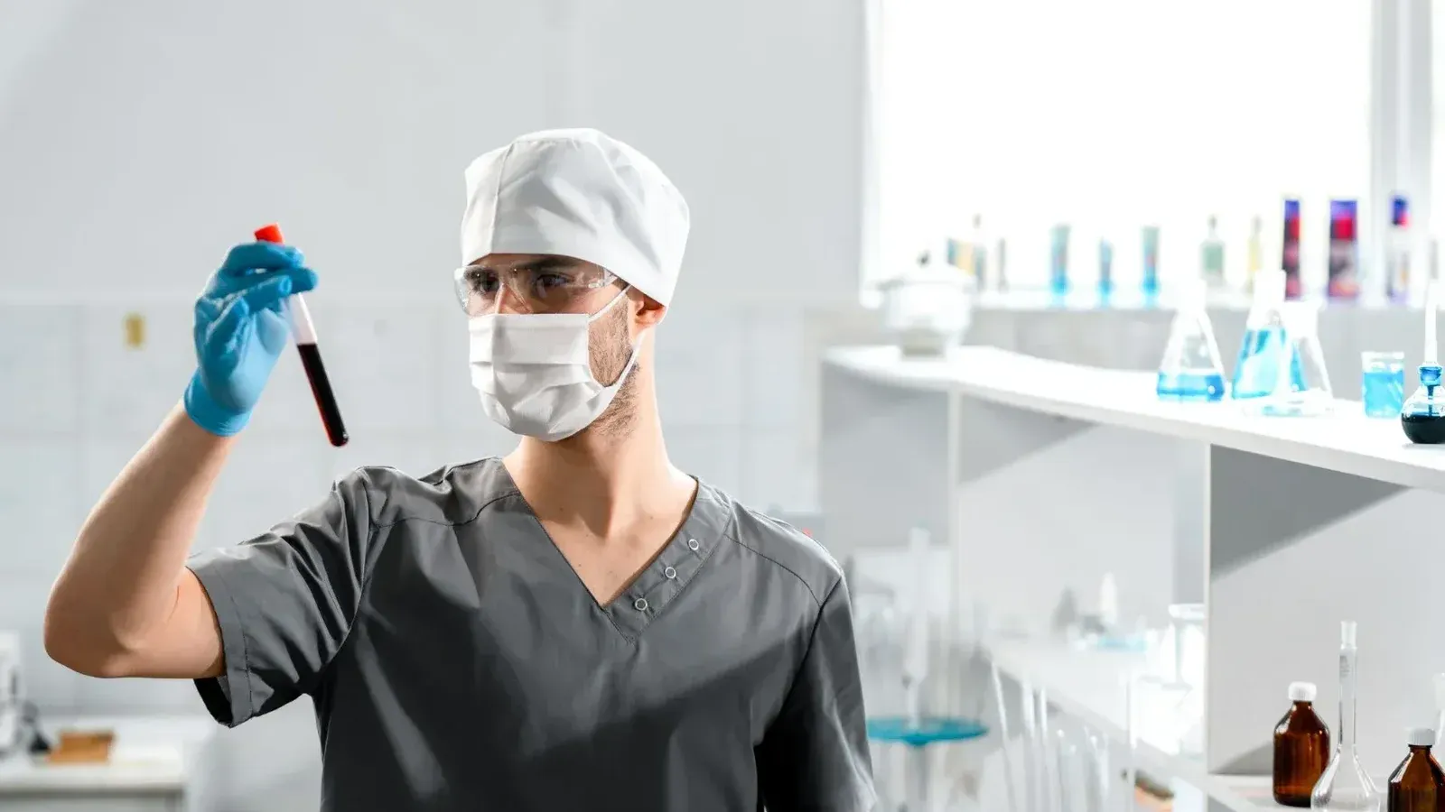 Un profesional médico que analiza una muestra de sangre en un entorno de laboratorio brillante.