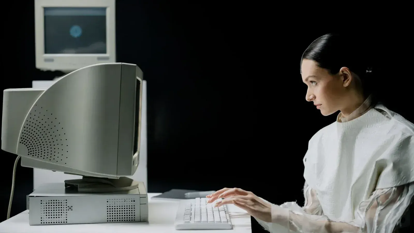 Una mujer escribiendo en una computadora CRT retro en un moderno laboratorio.