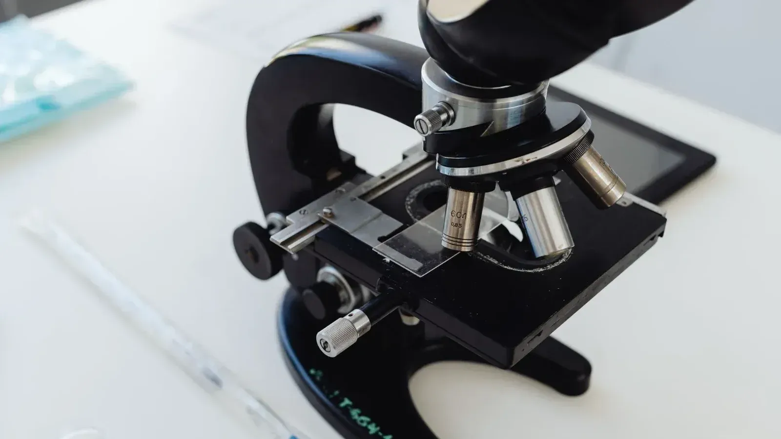 Foto detallada de un microscopio en un escritorio de laboratorio, simbolizando la investigación científica.
