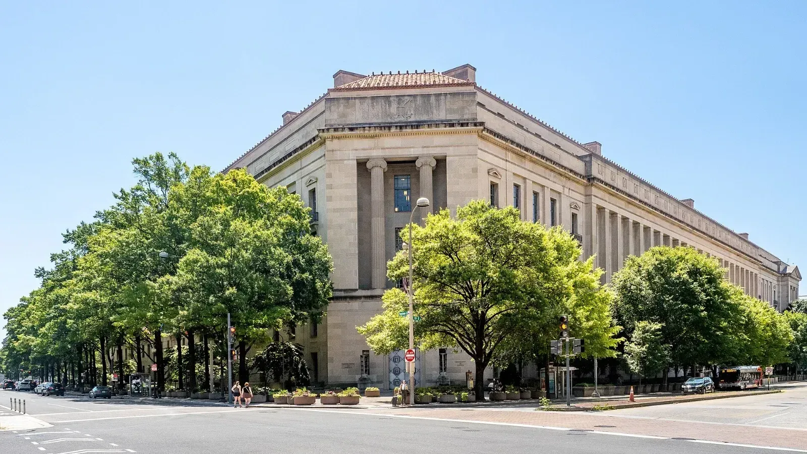 Fachada del edificio Robert F. Kennedy, sede del Departamento de Justicia de Estados Unidos en Washington, rodeada de árboles en un día soleado