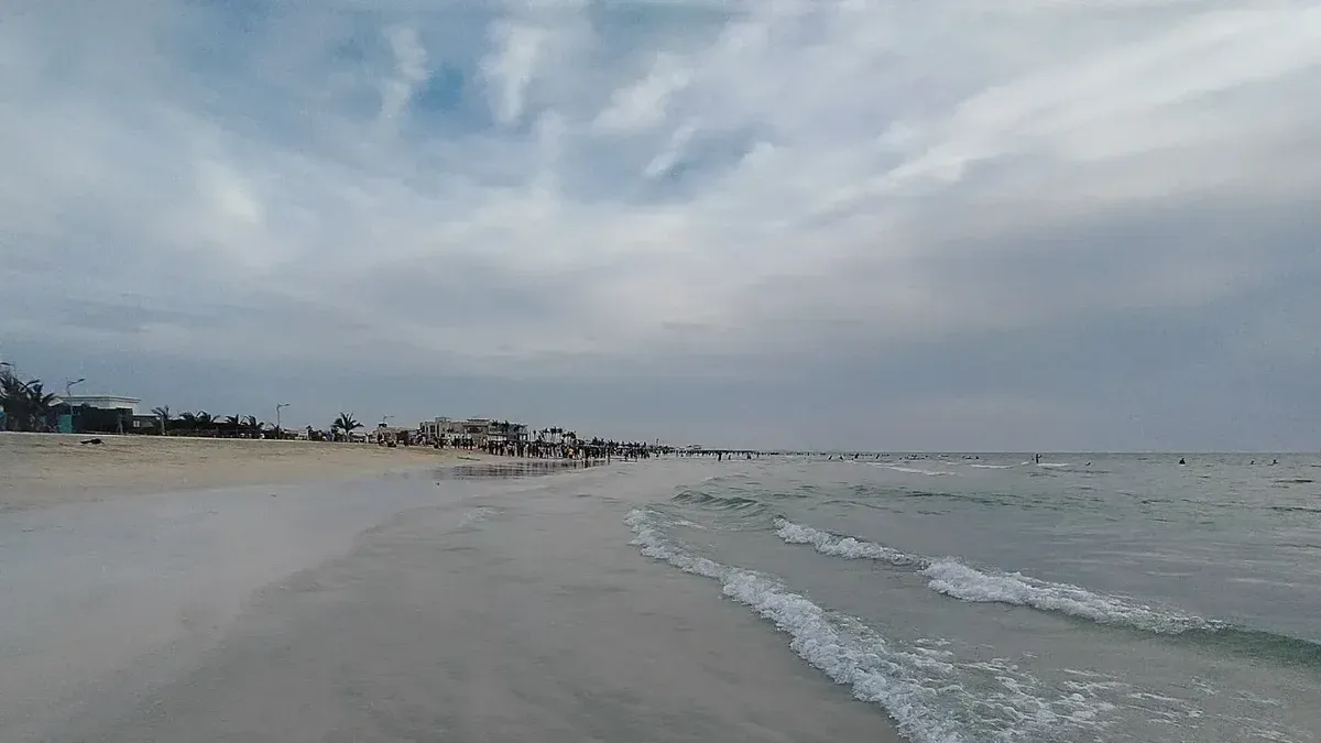 A photo of the Umm Al Quwain beach shores by sunset with the fine sand and clear waters