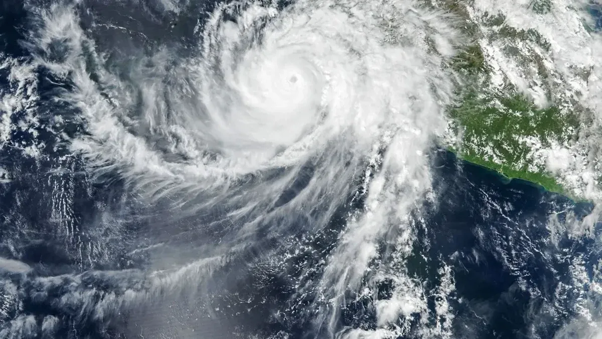 El ojo bien definido del huracán Simon se encuentra justo al lado de la costa del Pacífico de México. Algunas bandas de nubes externas de la tormenta en espiral se extienden sobre la tierra.