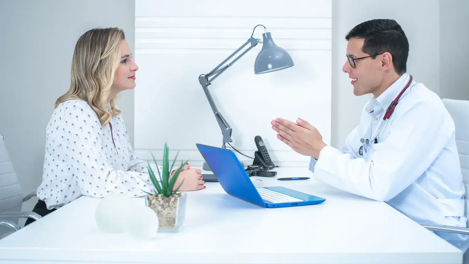 A doctor conducts a patient consultation in a bright, modern medical office.