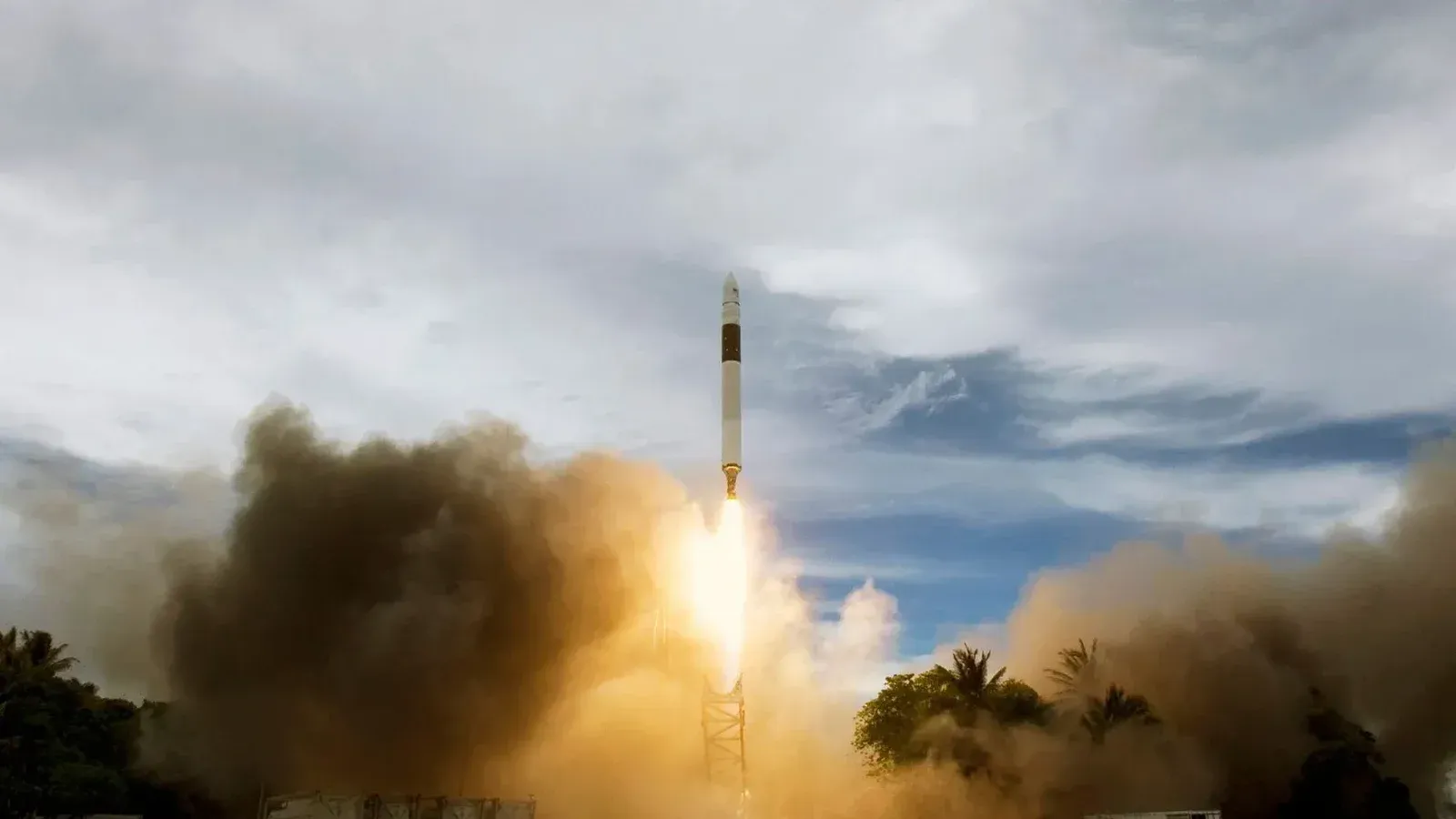 Nubes de humo de gas alrededor de cohete durante el lanzamiento desde el puerto espacial contra el cielo nublado