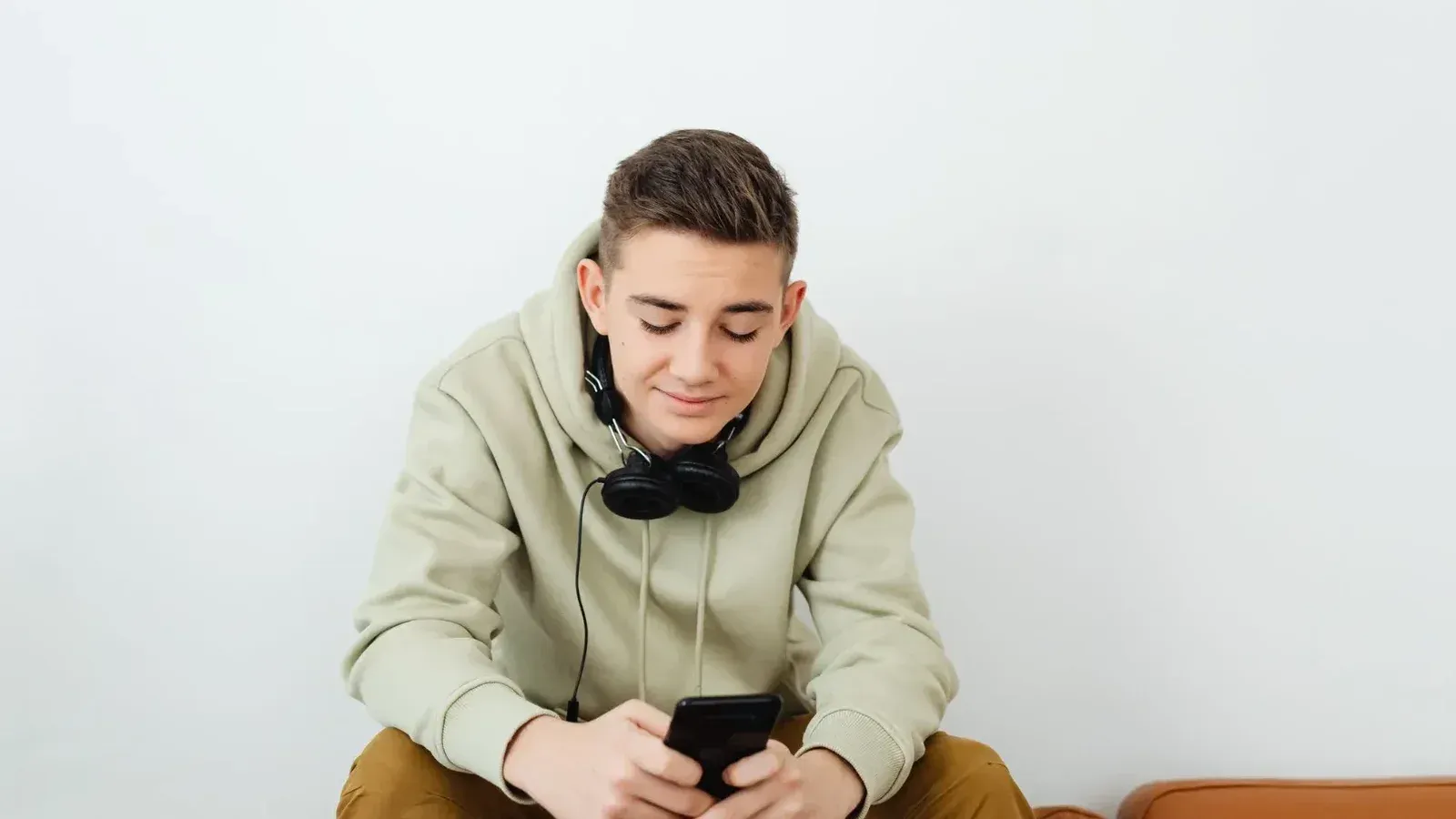 Young person enjoying technology, wearing casual clothes and headphones.