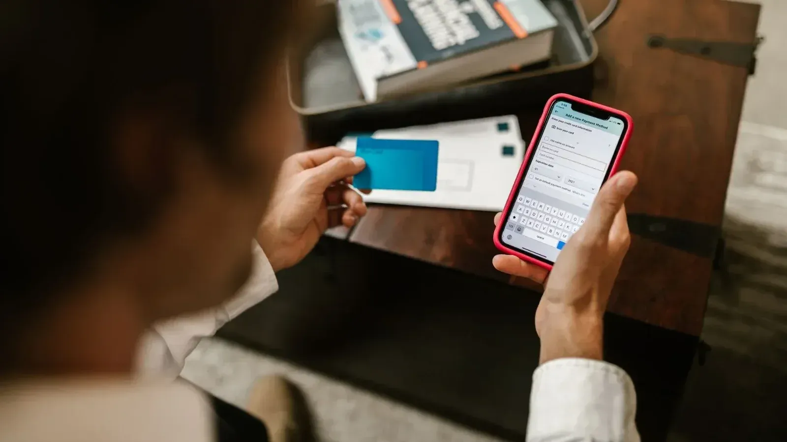 Persona que realiza un pago en línea con un smartphone y una tarjeta de crédito en el interior.