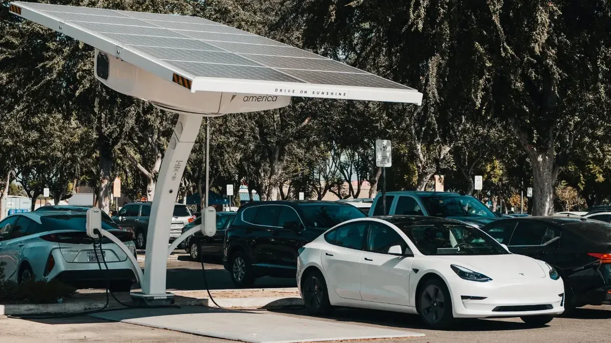 Coche eléctrico estacionado en una estación de carga solar al aire libre, destacando la energía renovable y la innovación.