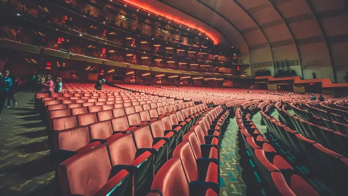 Expansive interior of a modern theater with rows of empty seats and warm lighting creating an inviting atmosphere.