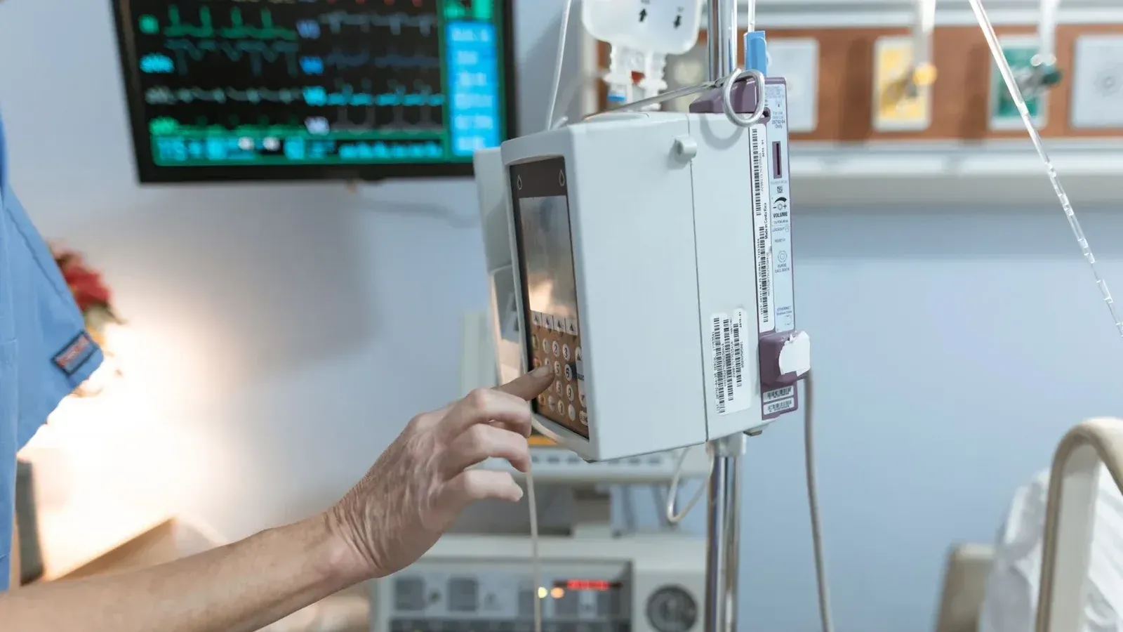 A healthcare worker operates a modern infusion pump in a hospital setting, ensuring precise medication delivery.
