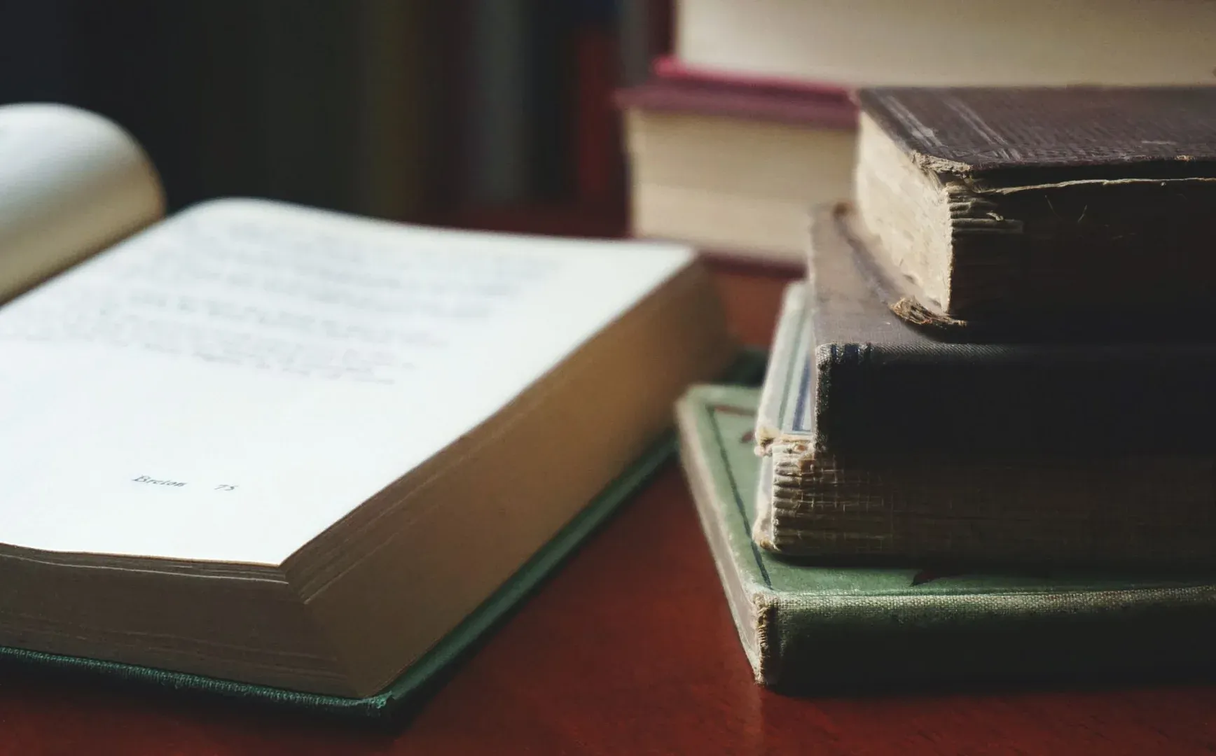Una colección de libros envejecidos apilados ordenadamente en una mesa de madera para los entusiastas de la lectura.