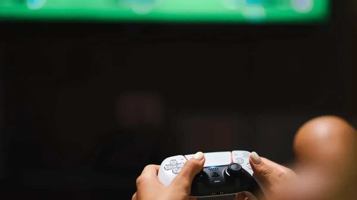 Close-up de manos sosteniendo un controlador de videojuego moderno mientras se juega.