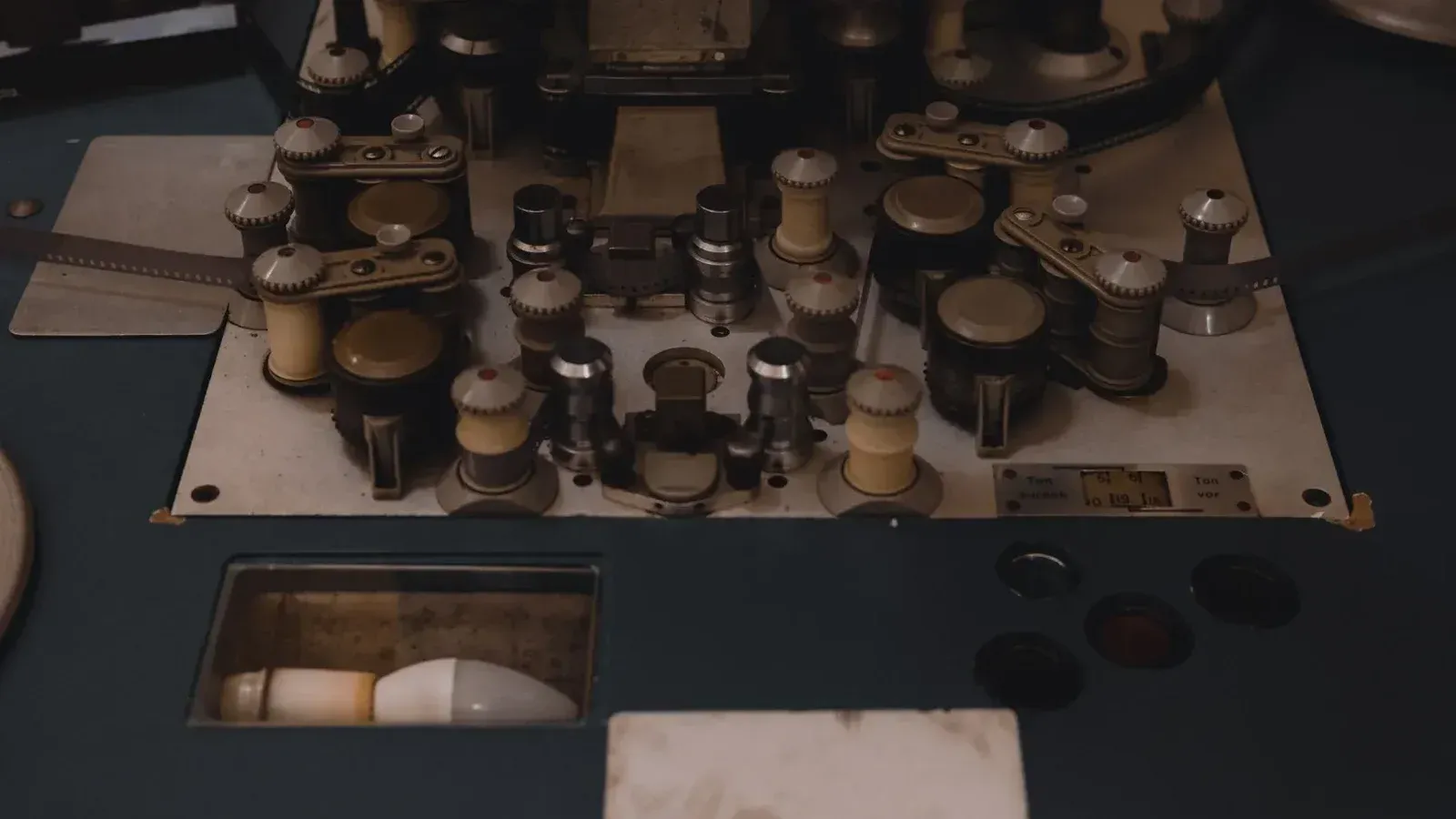 Closeup view of vintage film editing equipment, showcasing knobs and reels, perfect for retro film themes.