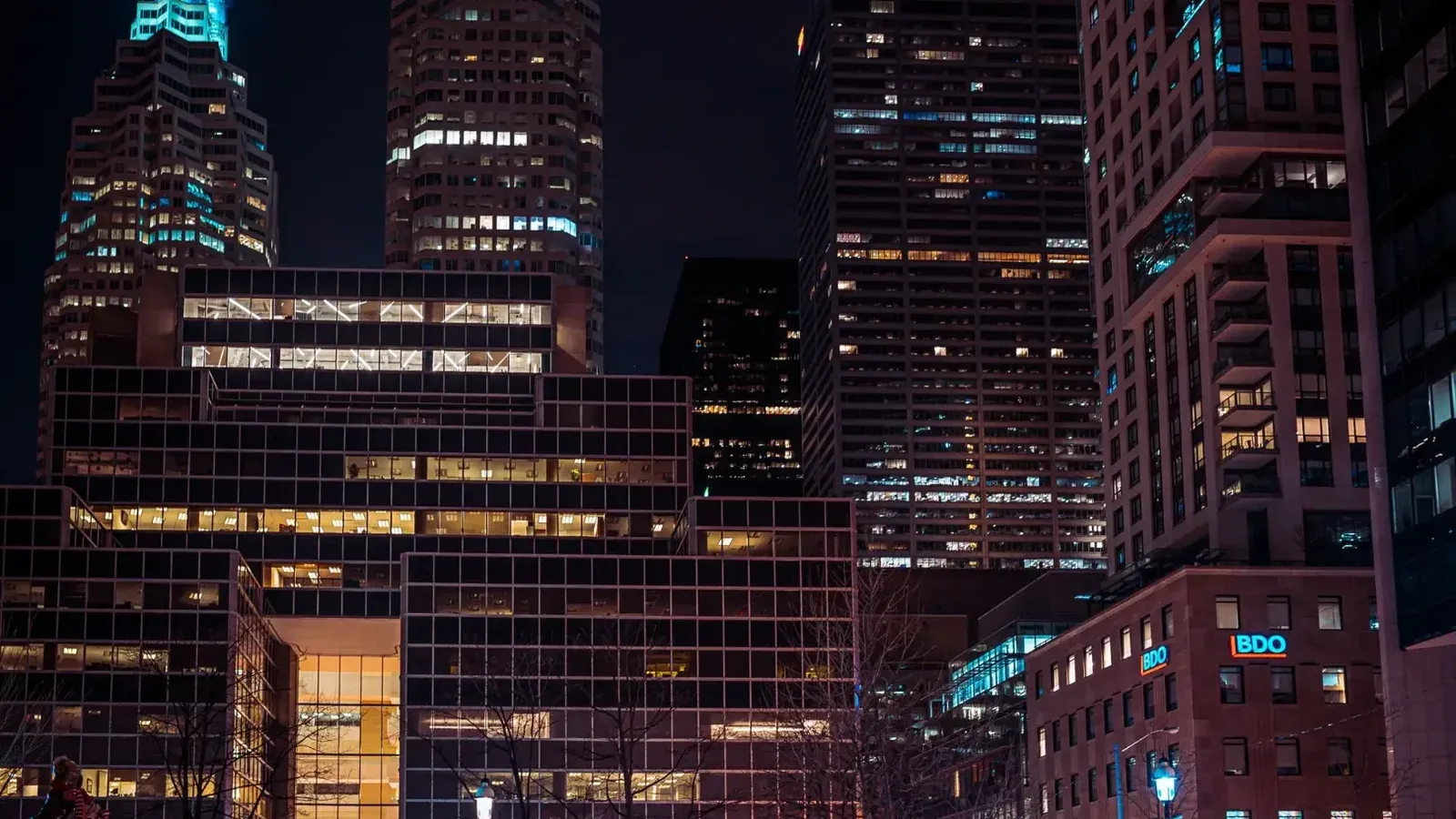 Vista nocturna de los rascacielos iluminados de Toronto que muestran la arquitectura urbana.