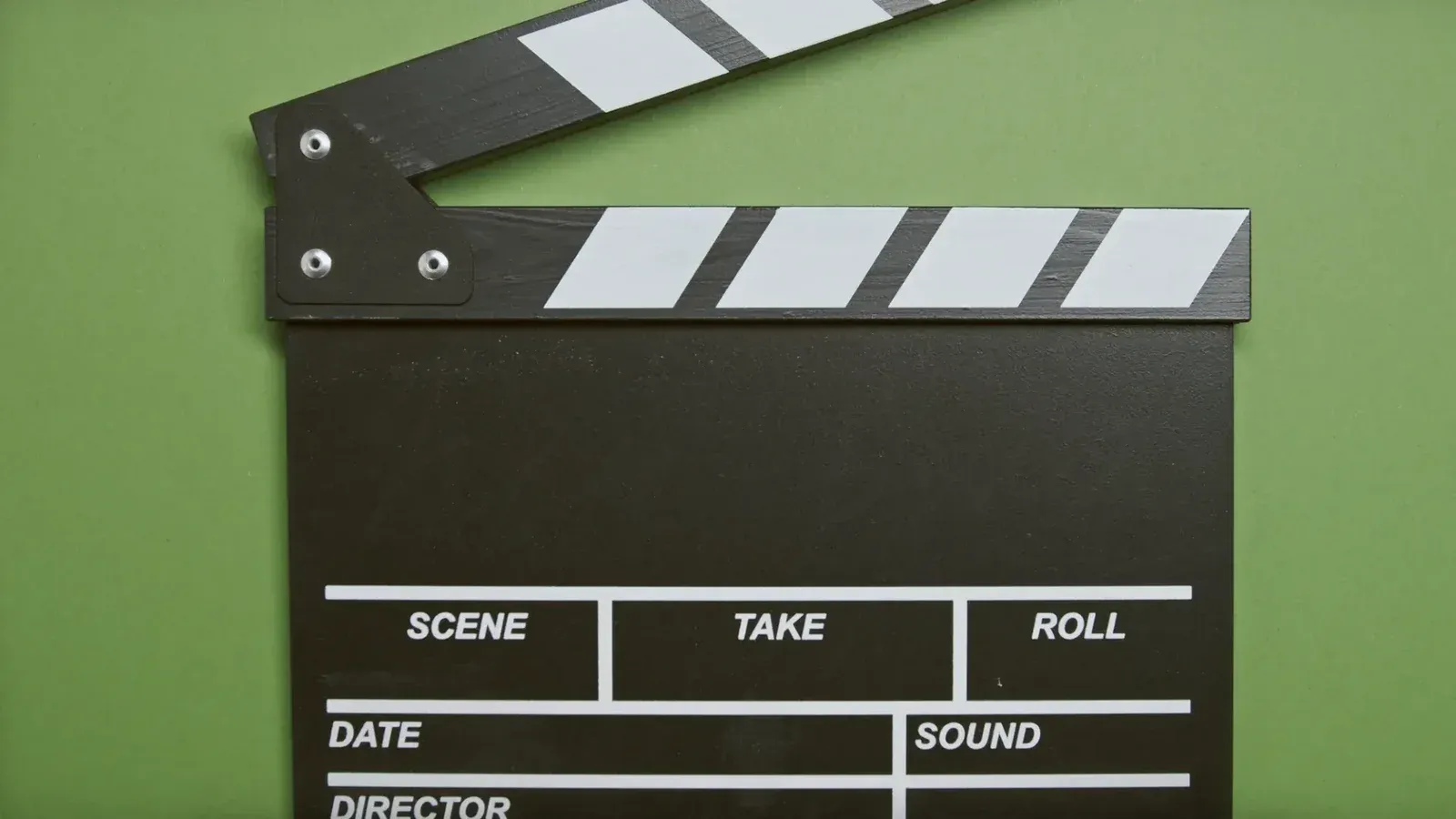 Una claqueta de película clásica sobre una superficie verde, esencial para escenas de cine.