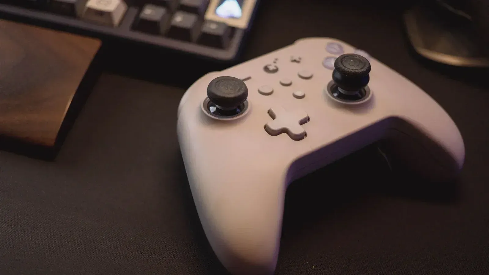 Controlador de juegos blanco en una configuración de escritorio negro, simbolizando juegos modernos.