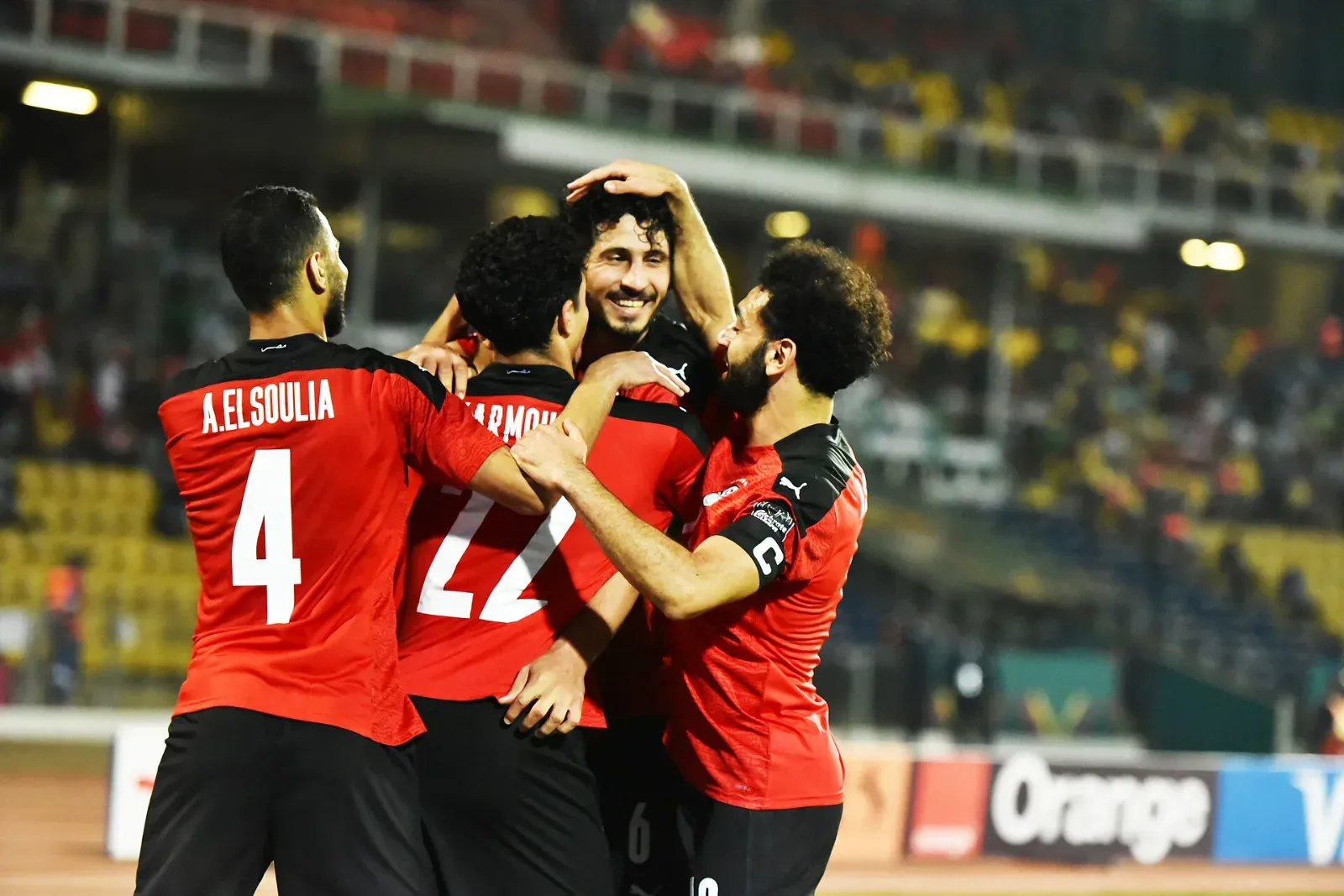 Jugadores de la selección de Egipto, de rojo, celebran un gol abrazados; en el centro, de espaldas, Omar Marmoush con el número 22.