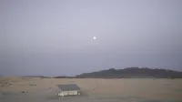 Serene view of an abandoned house in Samalayuca Desert under the early morning moonlight.