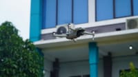 Aerial view of a drone flying near a modern building in Indonesia.