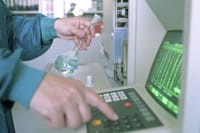 Close-up of a scientist operating lab equipment with a flask in hand.