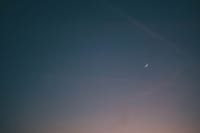 A tranquil scene of a crescent moon and star in the evening sky, evoking calmness and wonder.