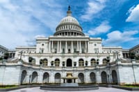 Exterior view of the iconic US Capitol Building on a sunny day in Washington, DC.