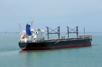 Cargo vessel navigating the calm waters of the open sea.