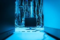 A complex network of cables in a data center with a monitor in the foreground.