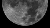 Close-up black and white photo of the moon showing lunar surface texture.