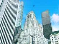 A stunning view of skyscrapers against a bright blue sky in Manhattan's downtown area.