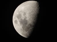 Detailed close-up of the moon's surface in the first quarter phase, showcasing craters and textures.