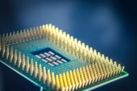 High-resolution macro shot of a computer CPU chip with gold pins against a blue background.