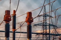 Detailed view of power transformers and lines against a sunset sky in Austria.