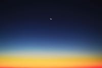 Crescent moon and planet visible in a colorful twilight sky over Mahajanga, Madagascar.