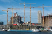A modern construction site with multiple cranes and buildings in progress.