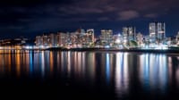 Captivating night cityscape of Viña del Mar with lights reflected over the ocean.