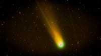 Colorful comet with glowing trail streaking across a starry night sky.