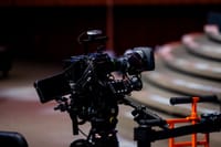 High-end video camera rig set up in indoor auditorium with focus on film production.