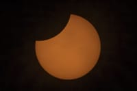 An impressive partial solar eclipse with the sun partially obscured by the moon.
