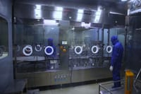 Workers in protective gear inside a sterile pharmaceutical manufacturing plant in Rawalpindi, Pakistan.