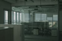 Spacious empty office with glass walls and city views, ideal for modern workspace settings.