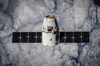 SpaceX Dragon spacecraft in orbit, highlighting advanced space technology with cloud backdrop.
