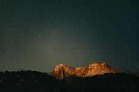 A serene night view of a mountain under a starry sky in Colorado Springs.