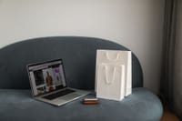 Online shopping setup with a laptop and shopping bags on a stylish couch.