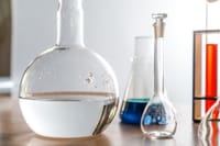 Close-up of laboratory glassware with various chemical solutions in a lab setting.