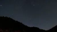 A breathtaking view of a star-filled night sky above silhouetted mountains, perfect for astronomy enthusiasts.